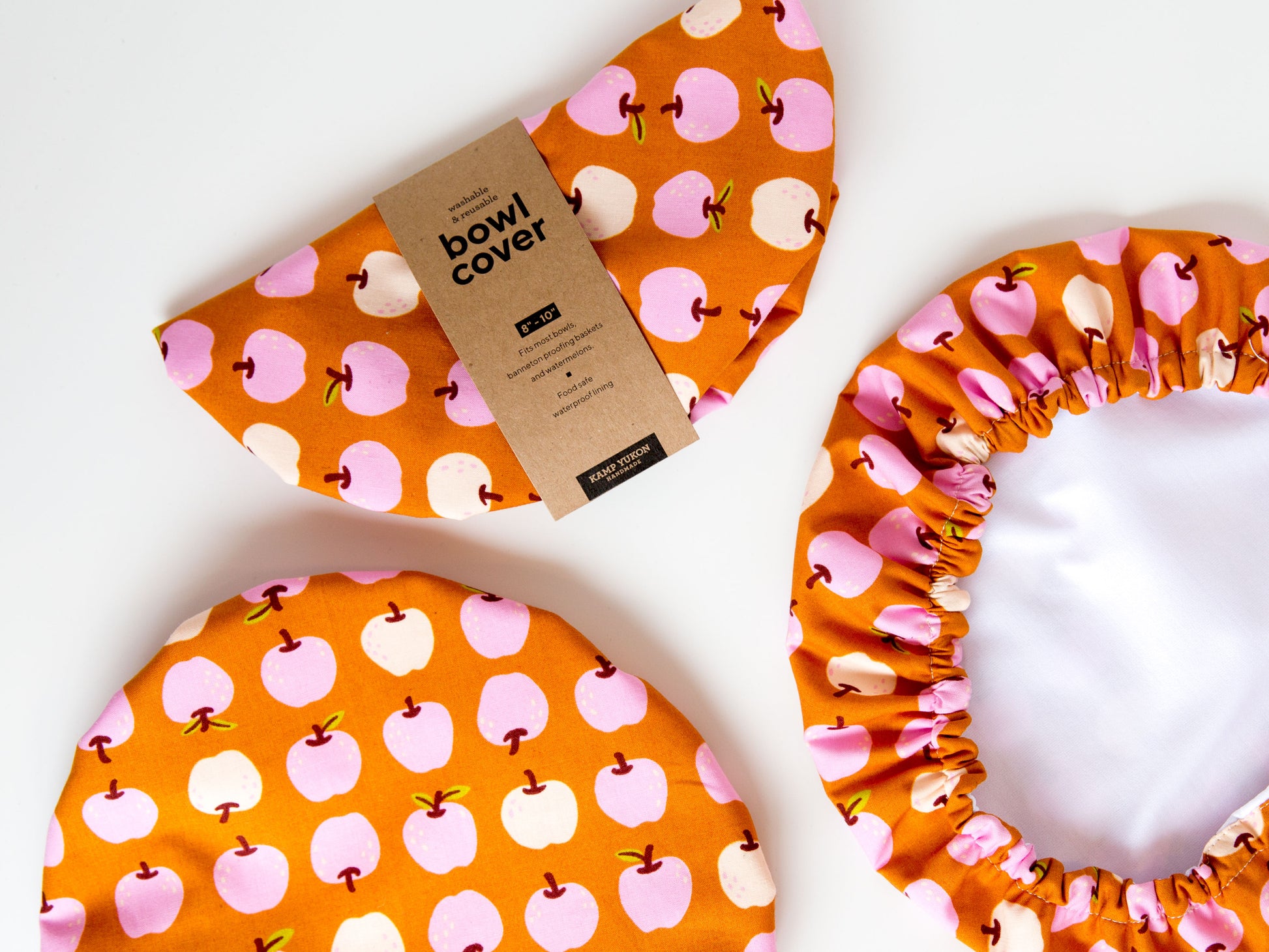 Rusty orange bowl covers with cute pinks apples on them.