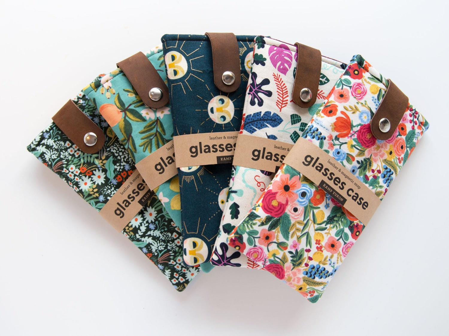 Five brightly colored glasses cases arranged with leather tabs