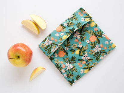 teal snack bag with oranges and lemons on it. 