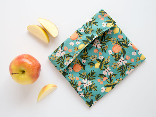 teal snack bag with oranges and lemons on it. 