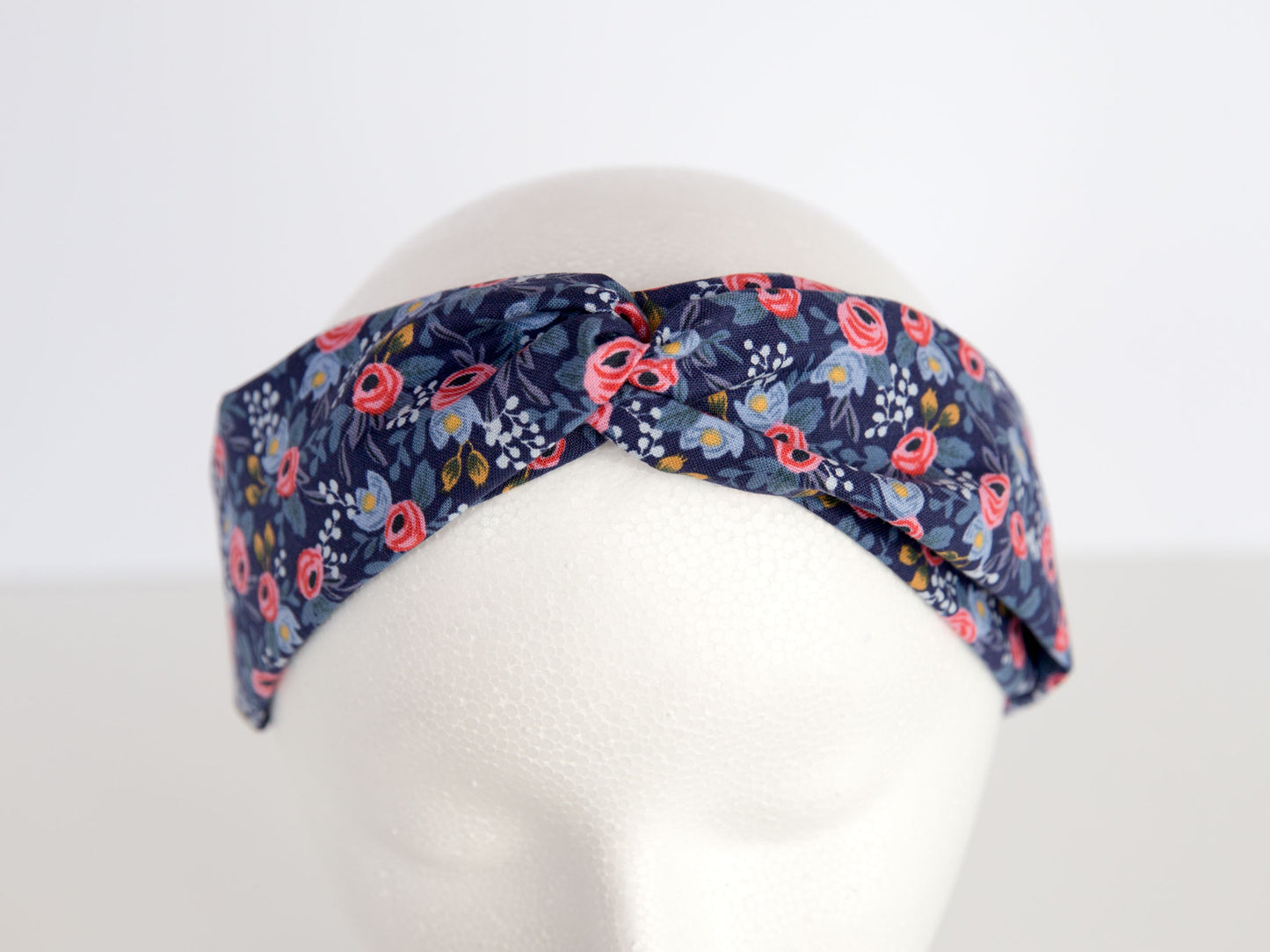 navy and pink rifle paper floral headband on a mannequin