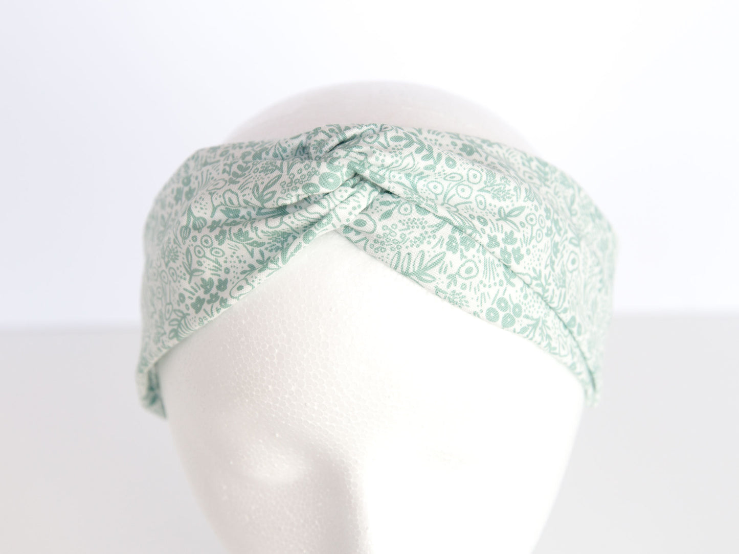 white and sage rifle paper floral headband on a mannequin